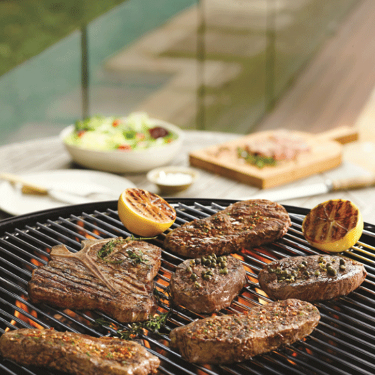 Barbecued T-bone steaks with herbs and peppercorns